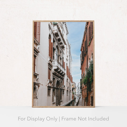 A framed art print depicting a narrow canal and surrounding architecture in Venice, Italy. The frame is not included with the purchase.