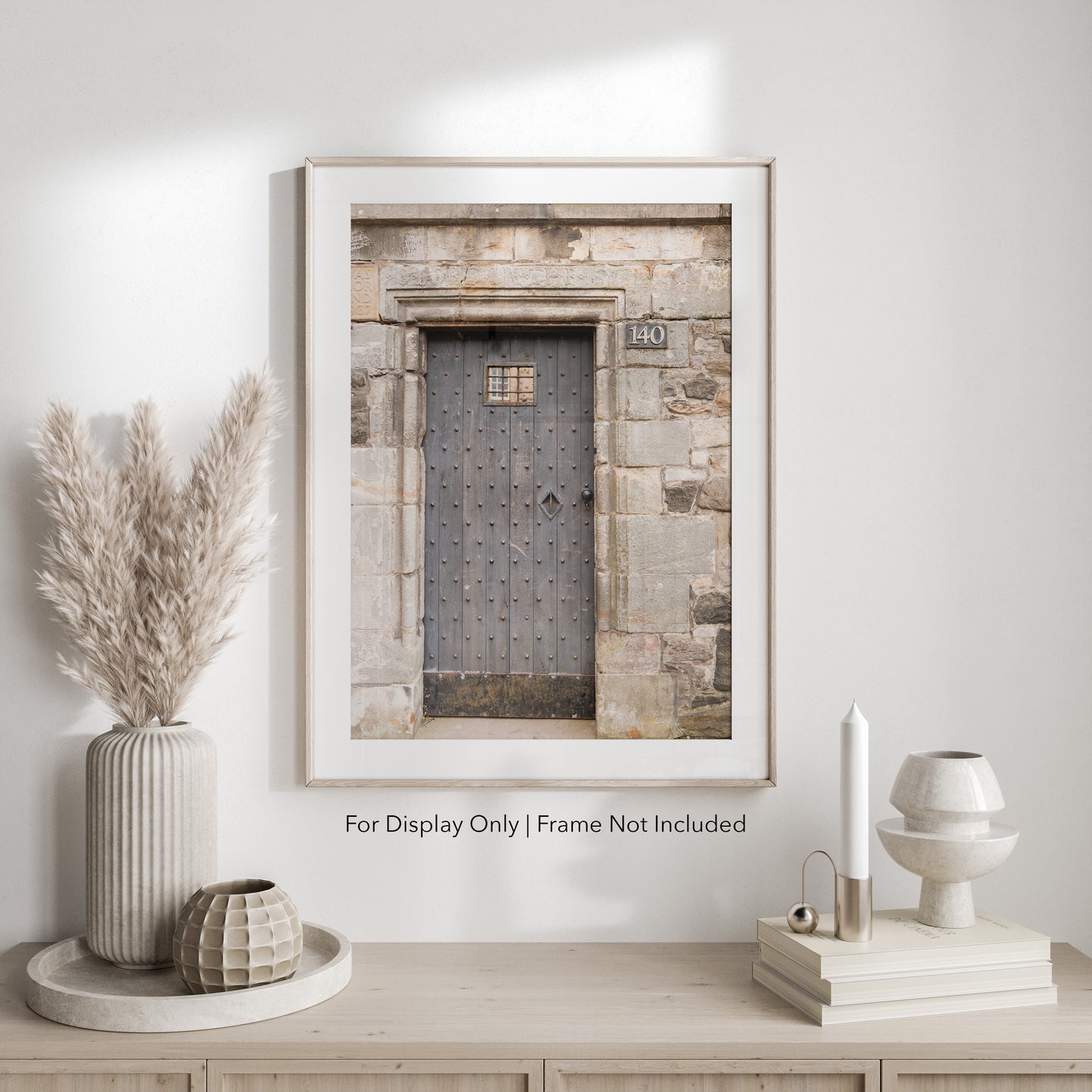 Rustic wooden door with iron studs set in a weathered stone wall, photographed in Edinburgh, Scotland.