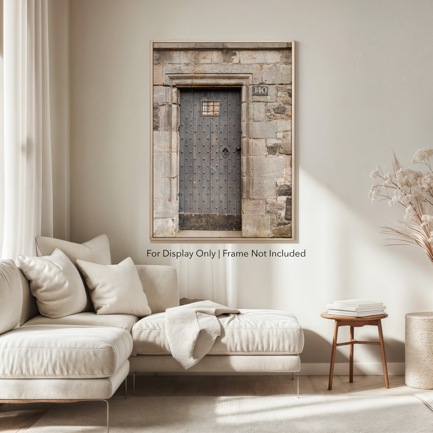 Rustic wooden door with iron studs set in a weathered stone wall, photographed in Edinburgh, Scotland.