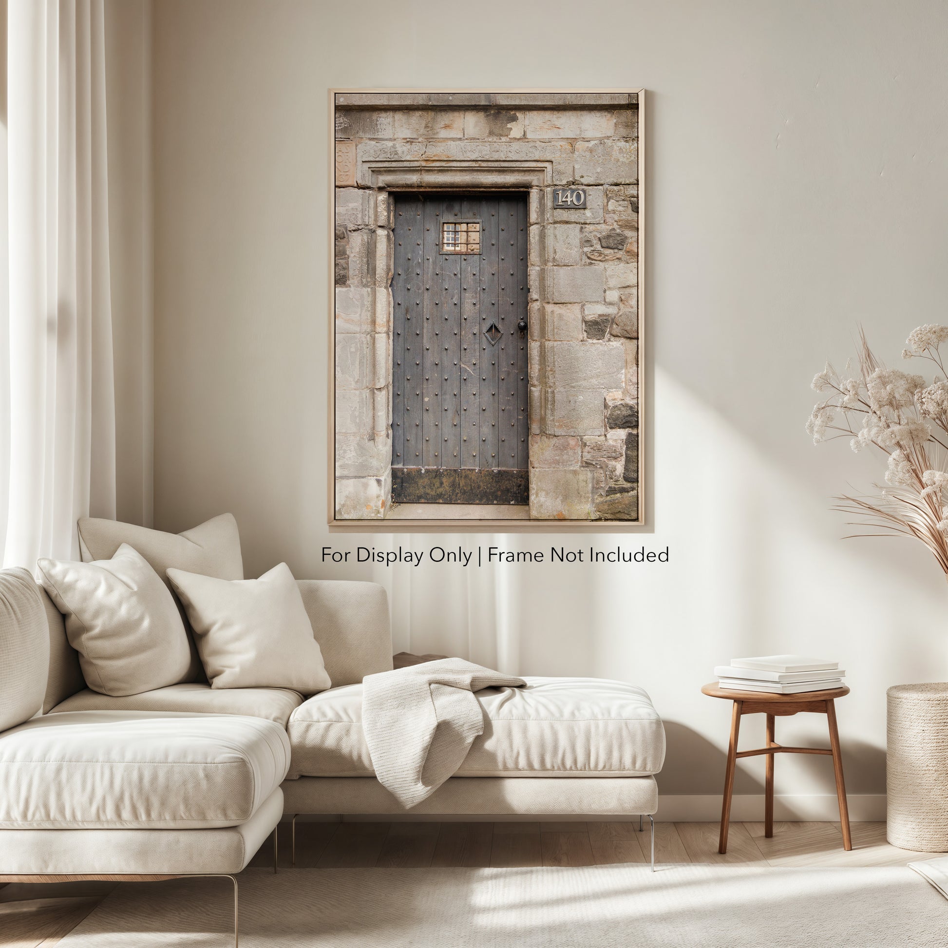 Rustic wooden door with iron studs set in a weathered stone wall, photographed in Edinburgh, Scotland.