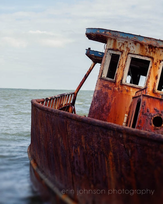 A photograph of an abandoned fishing boat in Apalachicola Bay, Florida, with a rustic and weathered appearance.