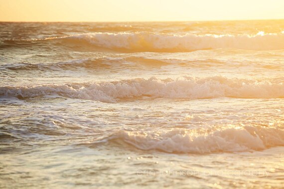 Landscape photograph of ocean waves at the beach lit by the sun during sunset