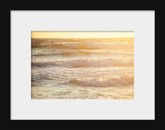 Landscape photograph of ocean waves at the beach lit by the sun during sunset