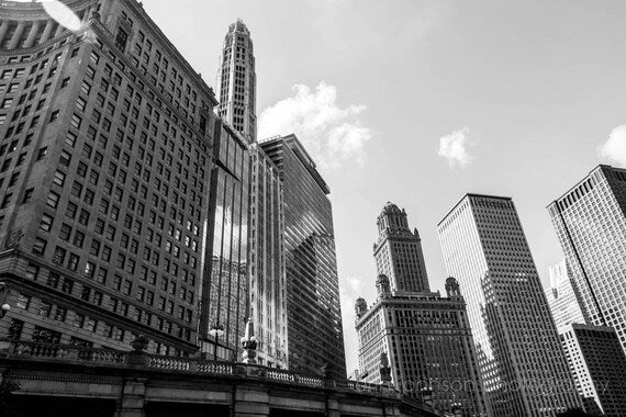 Black-and-white photograph of downtown Chicago skyscrapers with a body of water and bridges in the foreground.