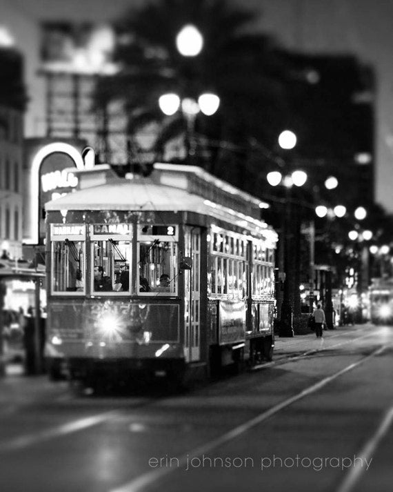 a black and white photo of a trolley on a city street