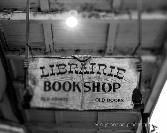 Black and white photograph of the sign for Librairie Bookshop in New Orleans, featuring text on a worn banner.