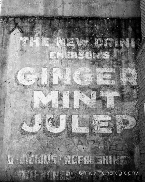 Black and white photograph of a vintage 'Ginger Mint Julep' advertisement in New Orleans' French Quarter.