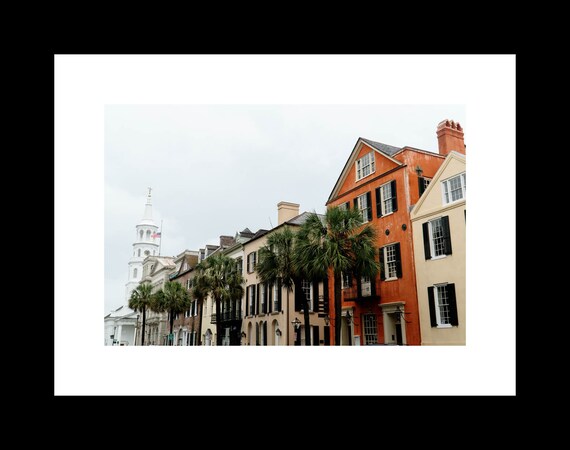 A photograph of a street in Charleston, South Carolina, showing historic buildings and palm trees along Broad Street.