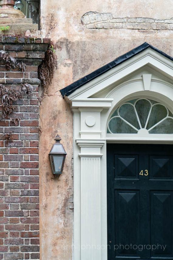 a black and white door and a brick wall