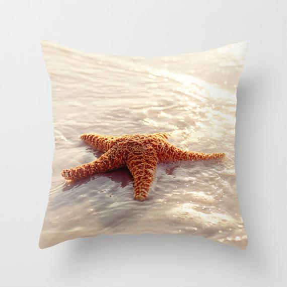 A throw pillow cover featuring a printed image of a starfish on a beach background.