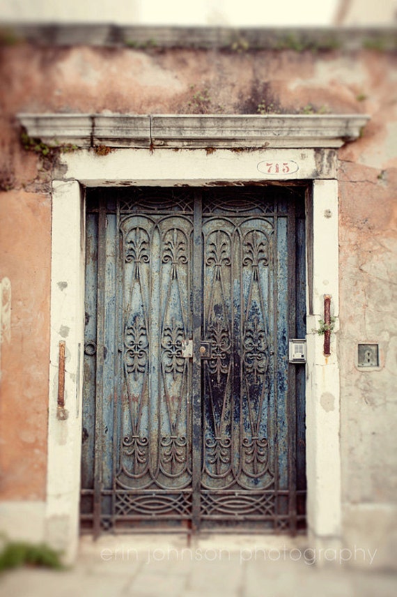 A photograph featuring a door with intricate ironwork and a pink and blue color scheme, labeled with a number and a white door frame in the background.