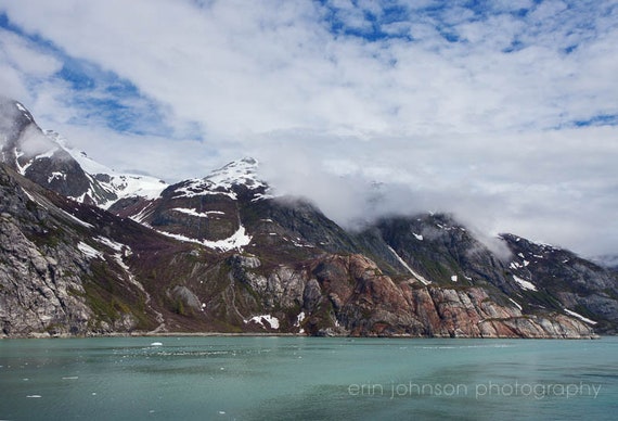 a mountain with snow on it and a body of water in front of it