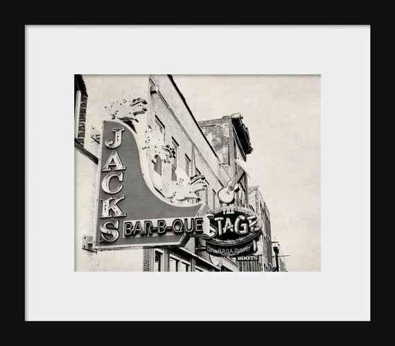 A black and white photograph of a Jack's BBQ sign on Broadway Street, Nashville, Tennessee.