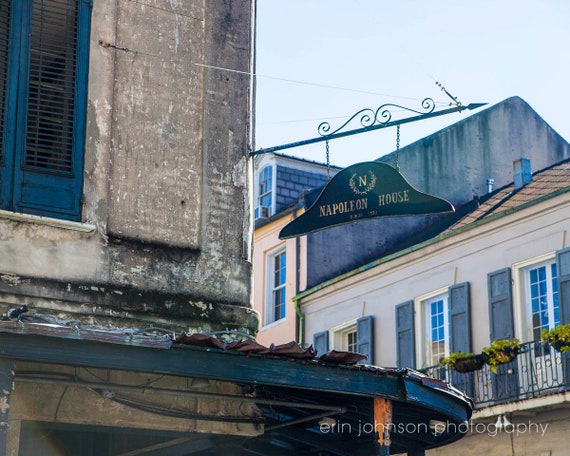 A photograph of a historical landmark sign for Napoleon House in the French Quarter, with a building's facade in the background.