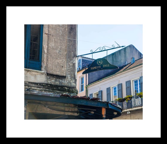 A photograph of a historical landmark sign for Napoleon House in the French Quarter, with a building's facade in the background.