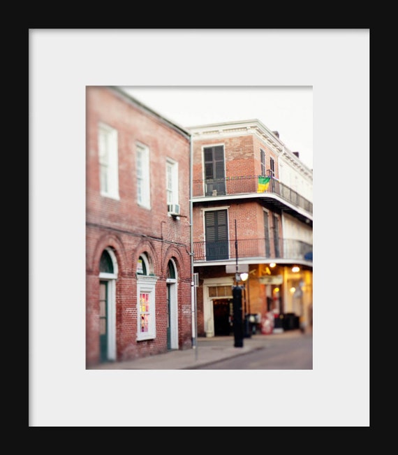 A photograph featuring a French Quarter street scene with buildings on either side of the street.