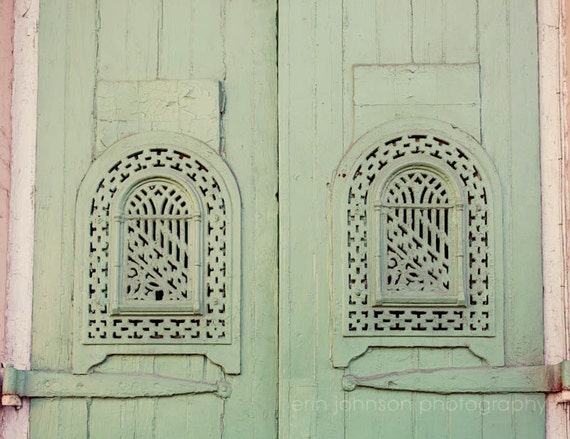 A photograph featuring green doors with intricate architectural details, likely to be used as a home decor piece.