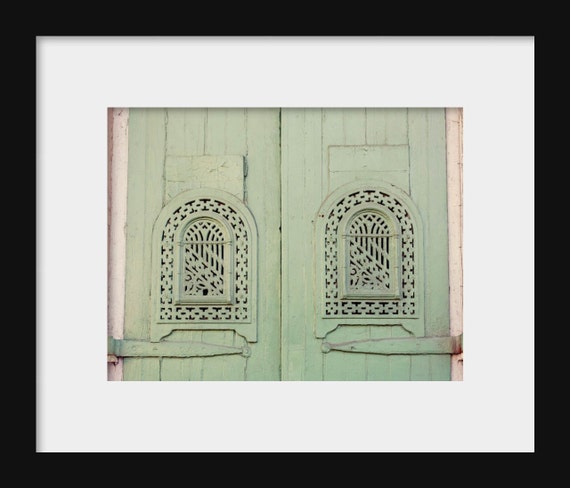 A photograph featuring green doors with intricate architectural details, likely to be used as a home decor piece.
