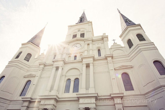 A photograph of the St. Louis Cathedral in New Orleans, Louisiana, featuring the cathedral's white architecture with a clear blue sky background.