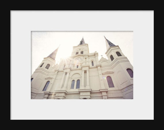 A photograph of the St. Louis Cathedral in New Orleans, Louisiana, featuring the cathedral's white architecture with a clear blue sky background.