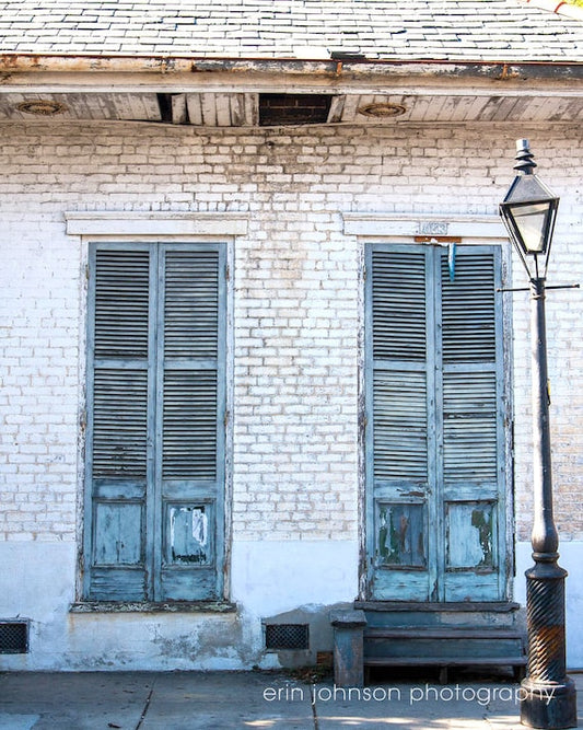 a white brick building with two windows 