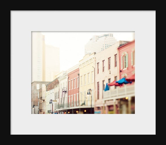 A photograph featuring a street in the French Quarter with colorful buildings.