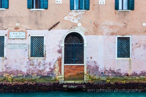 a building with a door and windows next to a body of water