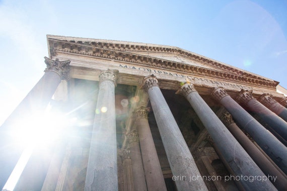 A high-resolution photograph of The Pantheon in Rome, Italy, showcasing the building's facade and architectural details with a clear blue sky in the background.