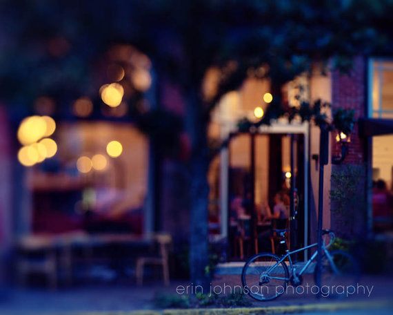 A nighttime photograph of a cafe with lit streetlights and a tree in front, part of a series on Savannah, Georgia, photography.