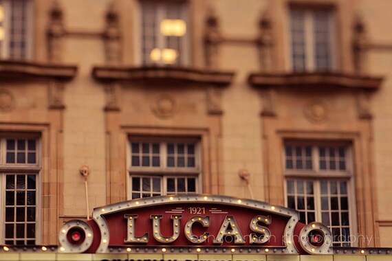 A photograph of the Lucas Theater in Savannah, Georgia, featuring the building's facade and a red-hued sign.