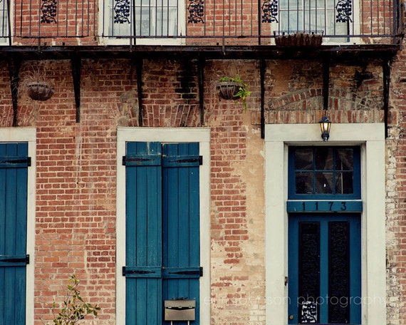 a red brick building with blue shutters and a clock