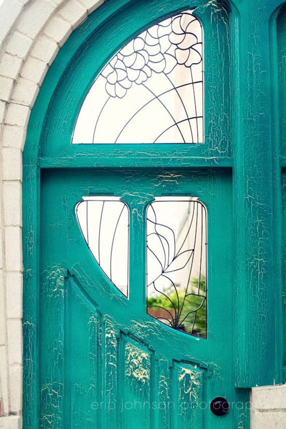 Vibrant teal door framed by rustic brick and greenery in Waco, Texas, capturing Southern charm and architectural detail.