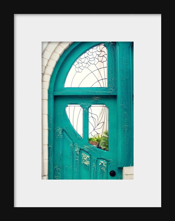 Vibrant teal door framed by rustic brick and greenery in Waco, Texas, capturing Southern charm and architectural detail.