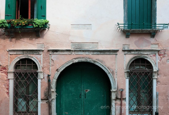 an old building with green doors and windows