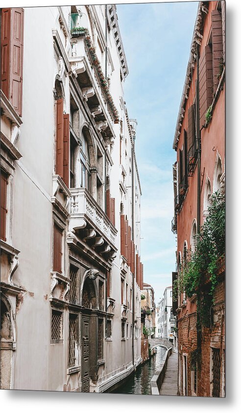 A metal print depicting a narrow canal in Venice, Italy, with buildings on either side, captured in a vertical orientation.