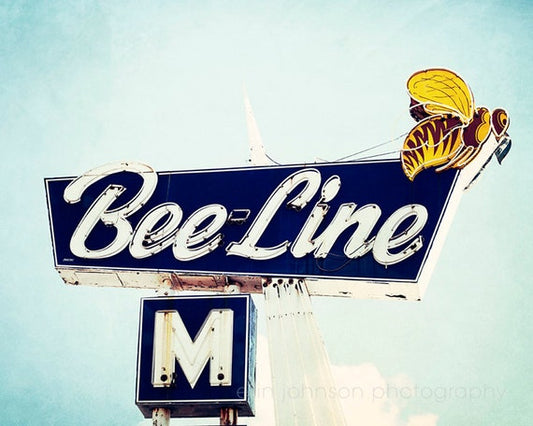 a bee line sign with a blue sky in the background