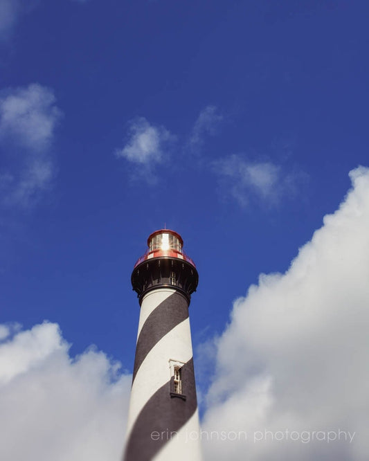 a black and white lighthouse under a blue sky