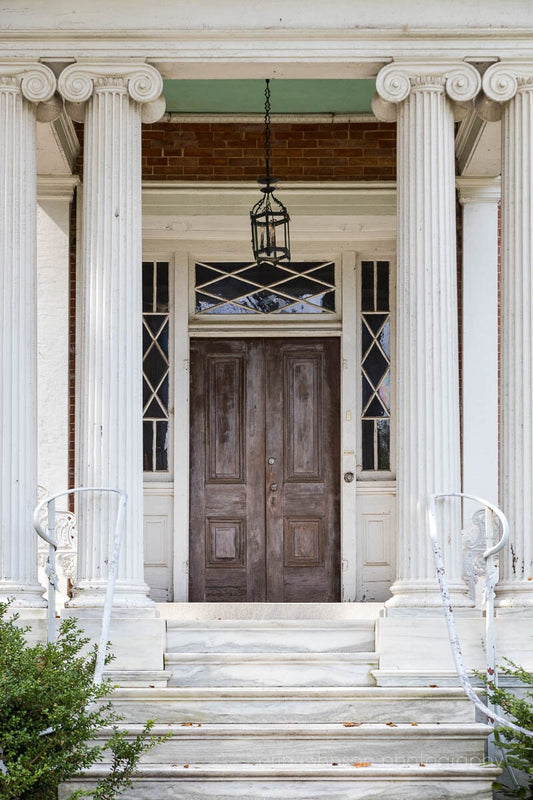 a large wooden door sitting next to a white building