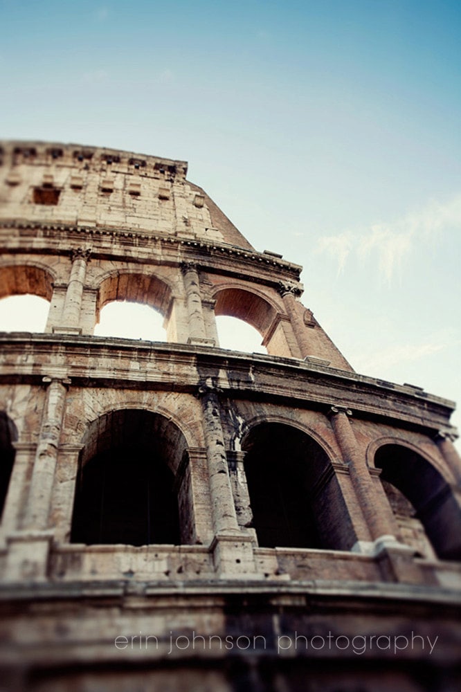 A high-resolution photograph of the Colosseum in Rome, Italy, showcasing the ancient Roman amphitheater's architectural details and the blue sky in the background.