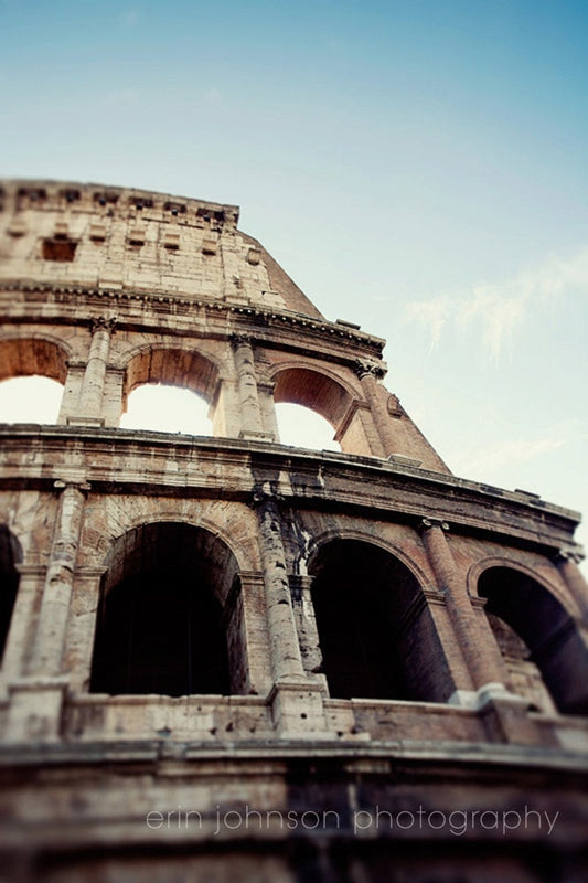 A high-resolution photograph of the Colosseum in Rome, Italy, showcasing the ancient Roman amphitheater's architectural details and the blue sky in the background.