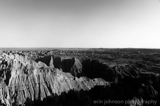 A black and white photograph of a scenic overlook in Badlands National Park, with bold lines and a classic composition.