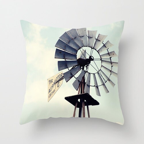 A decorative throw pillow with a rural windmill design and a blue color scheme on a white background.