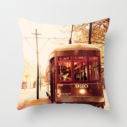 A decorative throw pillow cover featuring a vintage image of a St Charles streetcar on a street with trees and a clear sky in the background.