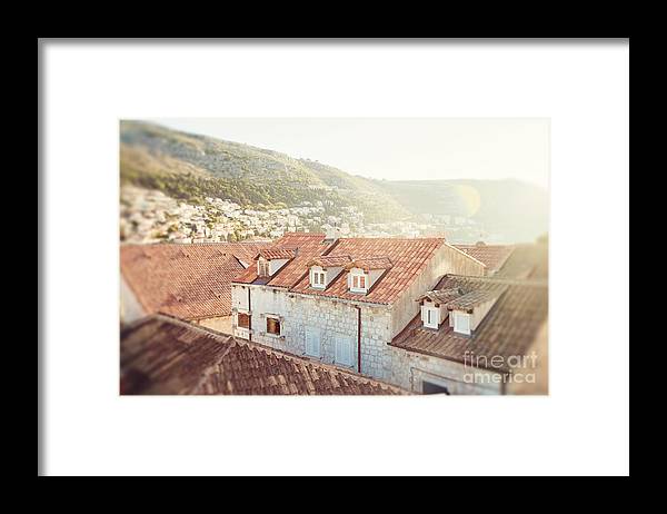 an old building with a red roof and a mountain in the background