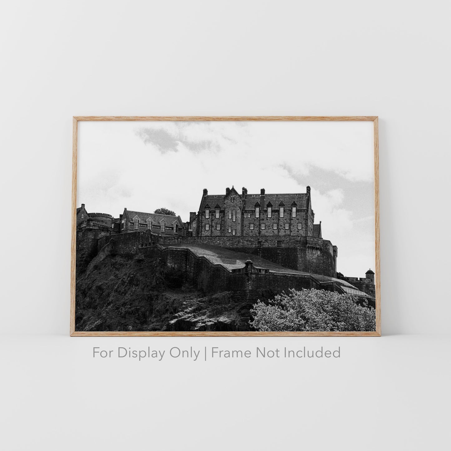 Black-and-white photograph of Edinburgh Castle perched on Castle Rock in Scotland, with dramatic stone walls and historic architecture.