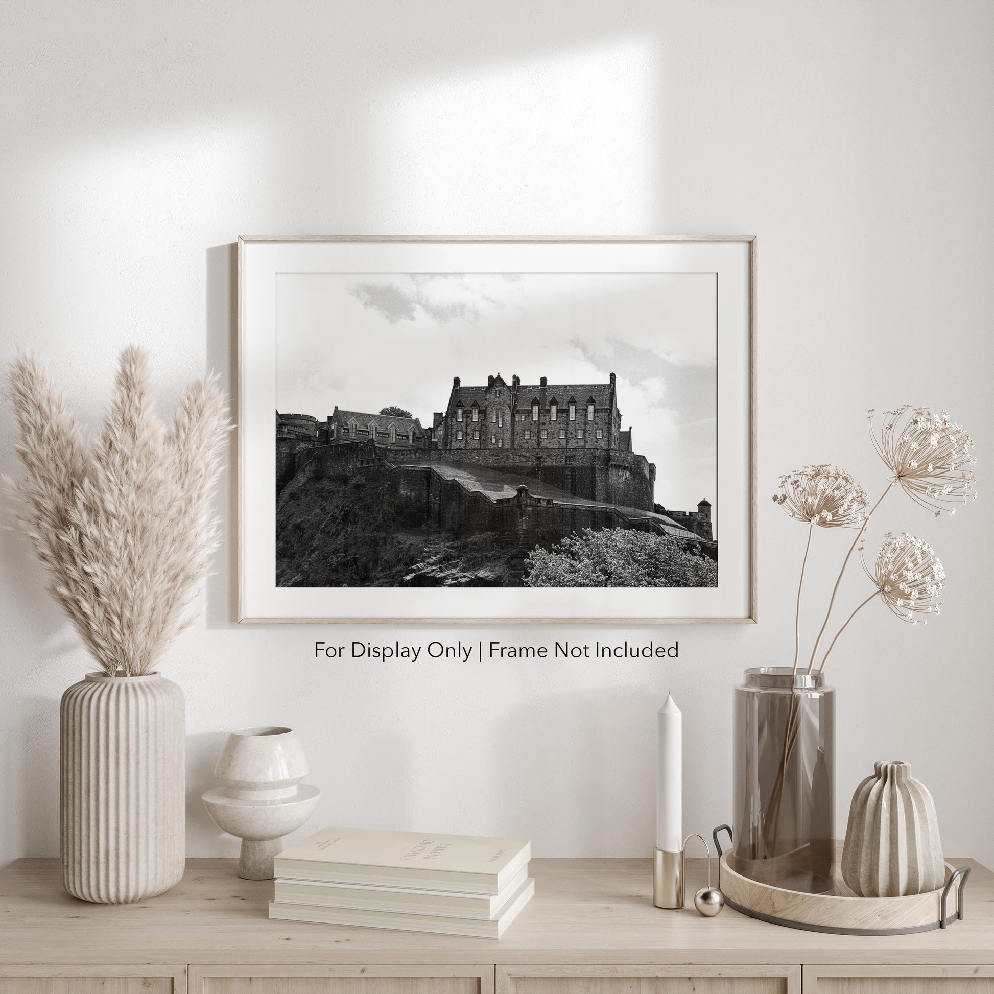 Black-and-white photograph of Edinburgh Castle perched on Castle Rock in Scotland, with dramatic stone walls and historic architecture.
