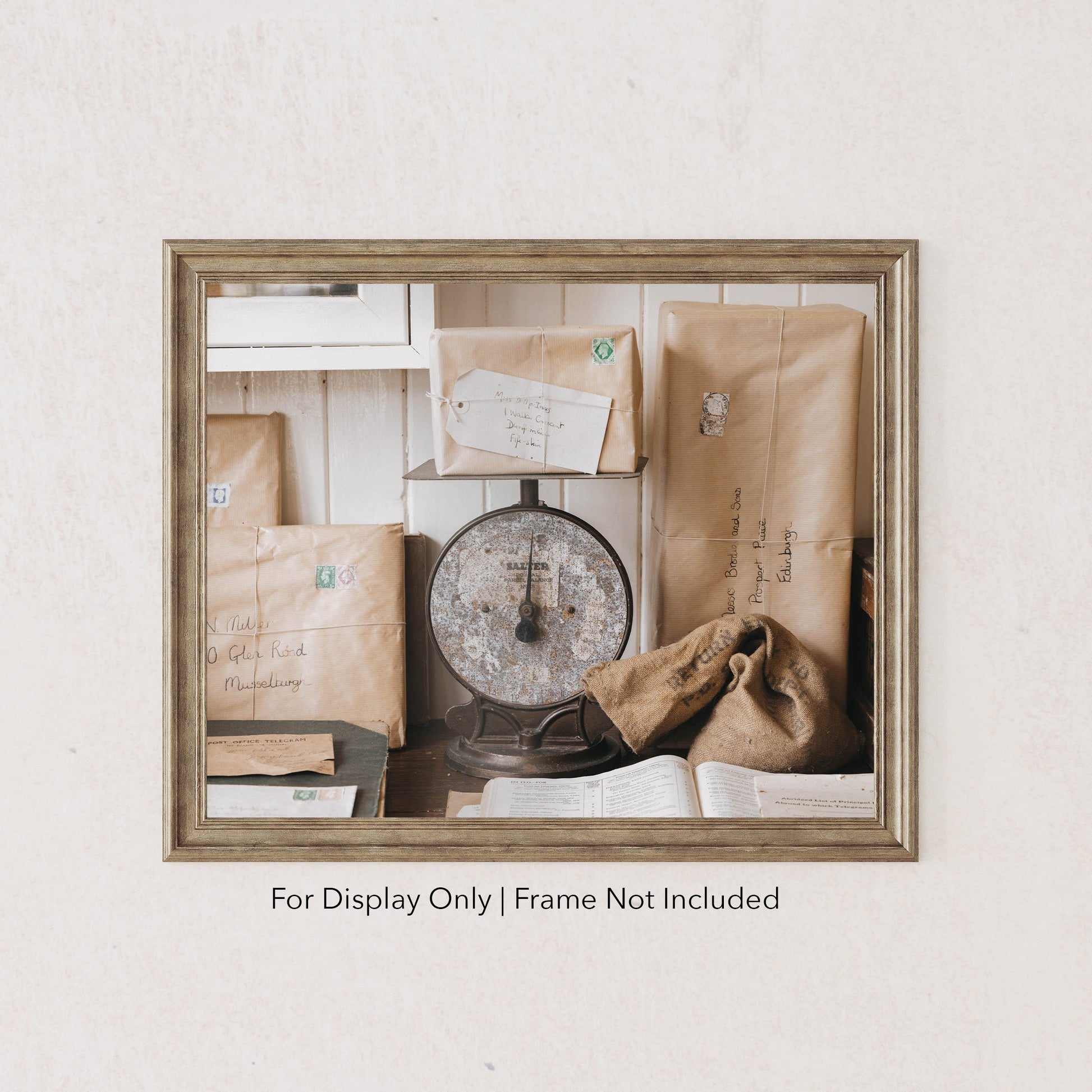 Rustic still life of vintage parcels wrapped in brown paper with stamps, stacked around a weathered post office scale.