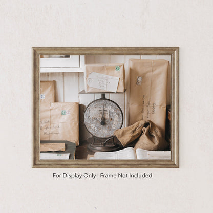 Rustic still life of vintage parcels wrapped in brown paper with stamps, stacked around a weathered post office scale.