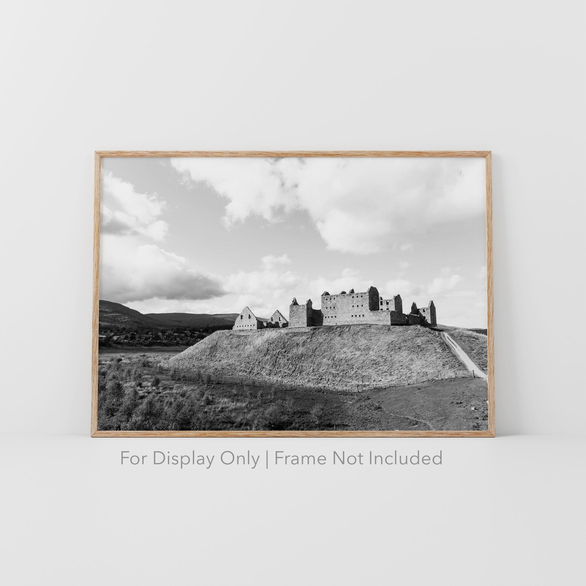 Black-and-white photograph of Ruthven Barracks ruins in the Scottish Highlands, set on a grassy hill with dramatic skies.