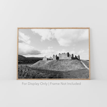 Black-and-white photograph of Ruthven Barracks ruins in the Scottish Highlands, set on a grassy hill with dramatic skies.